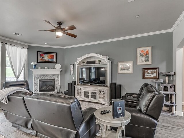 5608 Courtland Ln, Choctaw, OK 73020 - living room with ceiling fan, crown molding, a tile fireplace, wood finished floors, and baseboards