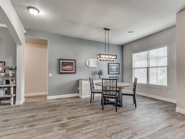 5608 Courtland Ln, Choctaw, OK 73020 - dining space featuring wood finished floors, baseboards, arched walkways, and a chandelier