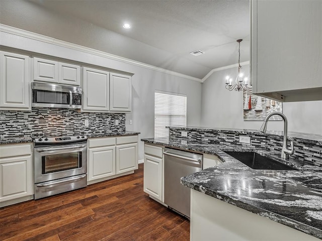 4033 NE 138th St, Edmond, OK 73013 - kitchen with stainless steel appliances, ornamental molding, a sink, dark wood finished floors, and decorative backsplash