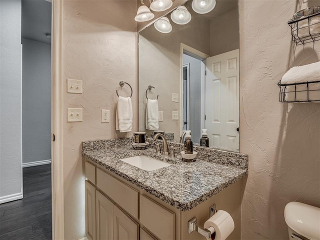 4033 NE 138th St, Edmond, OK 73013 - half bath featuring vanity, wood finished floors, toilet, a textured wall, and baseboards