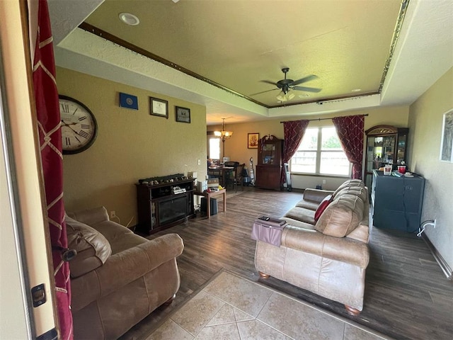 103 Thurman Dr, Walters, OK 73572 - living room featuring a tray ceiling, ceiling fan, a chandelier, tile patterned flooring, and baseboards