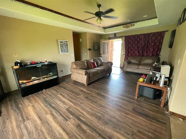 103 Thurman Dr, Walters, OK 73572 - living room featuring wood finished floors, ceiling fan, a raised ceiling, baseboards, and a textured ceiling