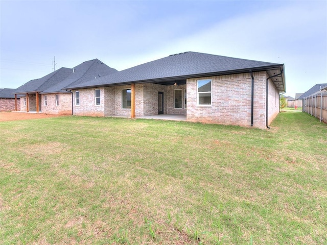 9316 NW 84th St, Yukon, OK 73099 - rear view of property featuring a patio, a yard, brick siding, and a shingled roof