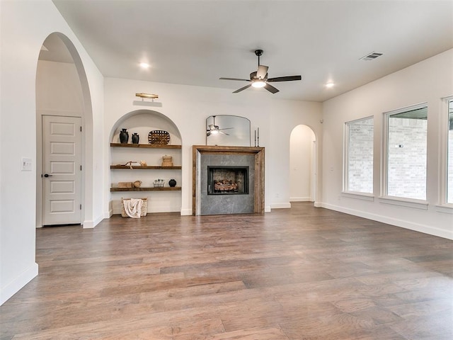 9316 NW 84th St, Yukon, OK 73099 - unfurnished living room with a ceiling fan, arched walkways, wood finished floors, a fireplace, and baseboards