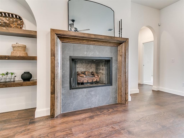9316 NW 84th St, Yukon, OK 73099 - detailed view of wood finished floors, a fireplace, baseboards, a ceiling fan, and arched walkways