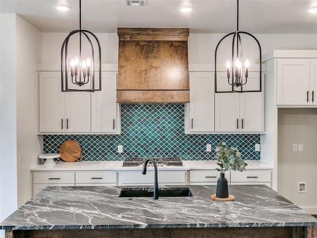 9316 NW 84th St, Yukon, OK 73099 - kitchen with a chandelier, a sink, an island with sink, and decorative backsplash