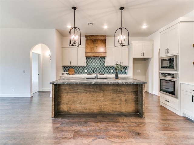 9316 NW 84th St, Yukon, OK 73099 - kitchen featuring oven, built in microwave, a chandelier, a sink, and dark stone counters