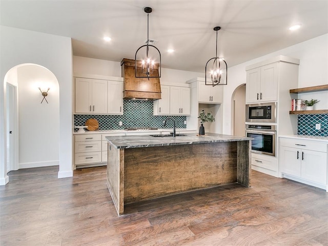 9316 NW 84th St, Yukon, OK 73099 - kitchen featuring appliances with stainless steel finishes, a sink, arched walkways, open shelves, and backsplash