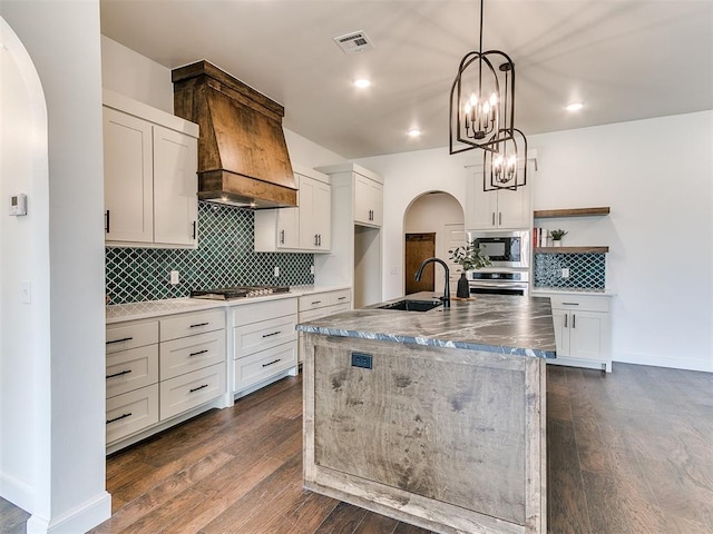 9316 NW 84th St, Yukon, OK 73099 - kitchen with appliances with stainless steel finishes, arched walkways, open shelves, a sink, and custom range hood