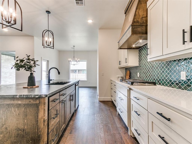9316 NW 84th St, Yukon, OK 73099 - kitchen featuring premium range hood, a chandelier, a sink, dark wood-type flooring, and an island with sink
