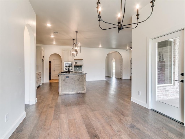 9316 NW 84th St, Yukon, OK 73099 - kitchen featuring a chandelier, arched walkways, white cabinetry, and open floor plan