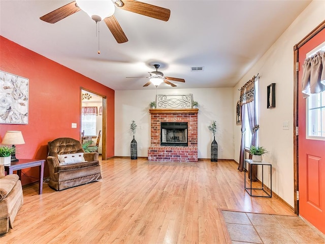 409 NW Jefferson Ave, Piedmont, OK 73078 - living area with ceiling fan, light wood finished floors, and a brick fireplace