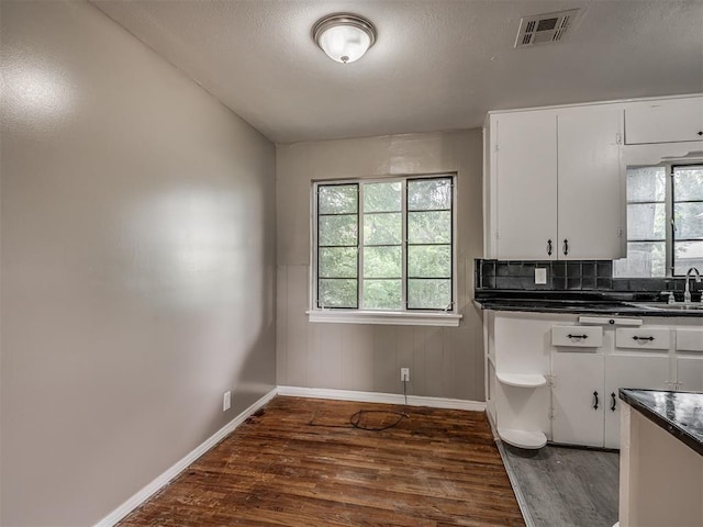4109 N Sterling Ave, Oklahoma City, OK 73122 - kitchen with dark wood-style floors, dark countertops, white cabinets, and a textured ceiling
