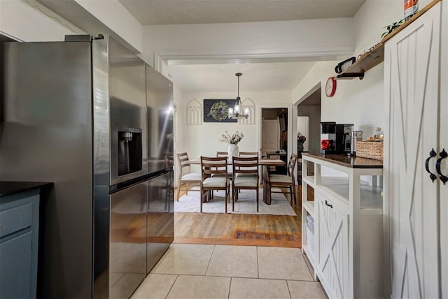 2805 SW 54th Pl, Oklahoma City, OK 73119 - kitchen featuring stainless steel refrigerator with ice dispenser, light tile patterned floors, and a chandelier