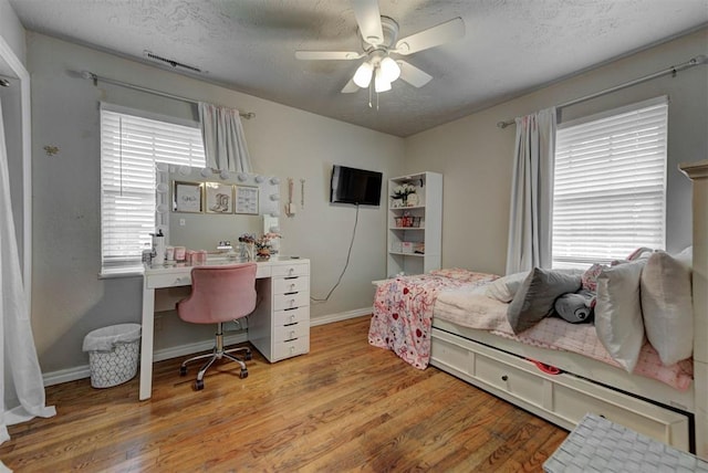 2805 SW 54th Pl, Oklahoma City, OK 73119 - bedroom with wood finished floors, a textured ceiling, a desk, baseboards, and a ceiling fan