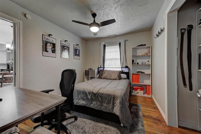 2805 SW 54th Pl, Oklahoma City, OK 73119 - bedroom with wood finished floors, a desk, a textured ceiling, and ceiling fan