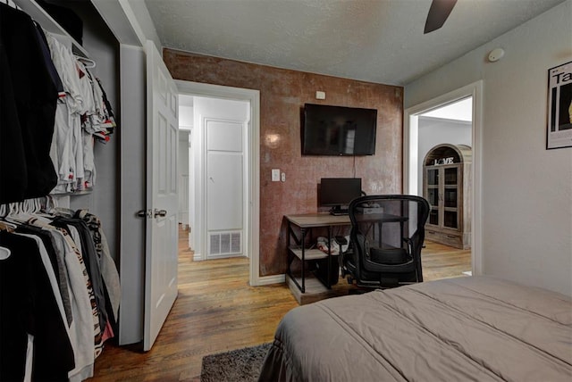 2805 SW 54th Pl, Oklahoma City, OK 73119 - bedroom with wood finished floors, baseboards, a textured ceiling, and ceiling fan