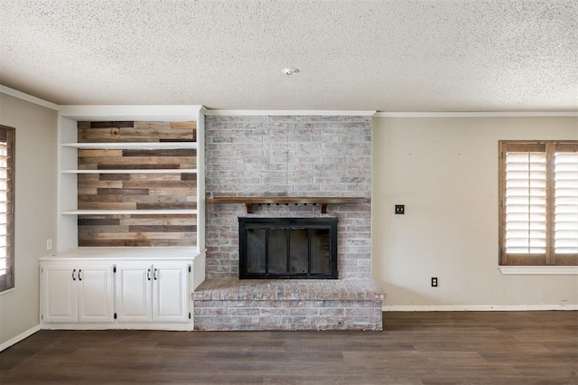 325 S Pine St, Crescent, OK 73028 - unfurnished living room with a textured ceiling, dark wood-style flooring, ornamental molding, a brick fireplace, and baseboards