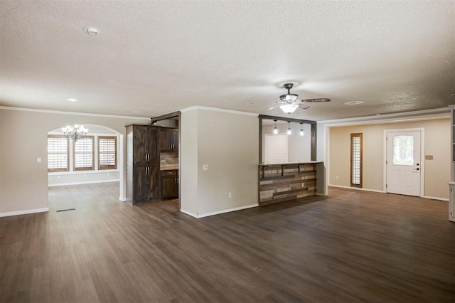 325 S Pine St, Crescent, OK 73028 - unfurnished living room with a textured ceiling, a chandelier, ceiling fan, baseboards, and crown molding