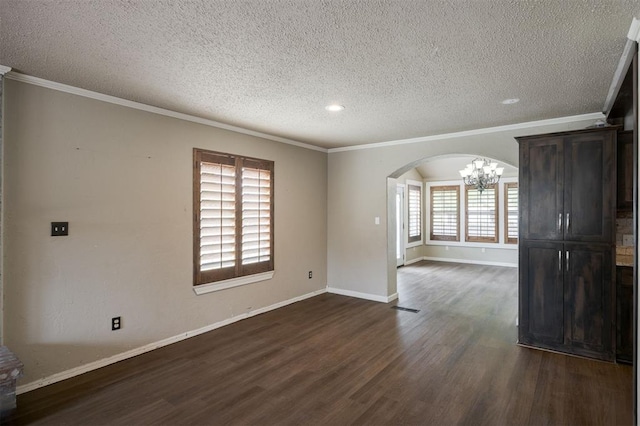 325 S Pine St, Crescent, OK 73028 - spare room with arched walkways, dark wood finished floors, a chandelier, a textured ceiling, and crown molding