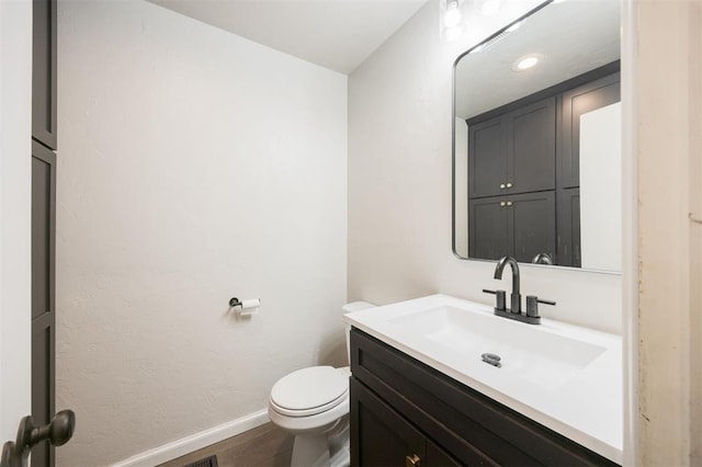 325 S Pine St, Crescent, OK 73028 - bathroom featuring vanity, toilet, baseboards, and wood finished floors
