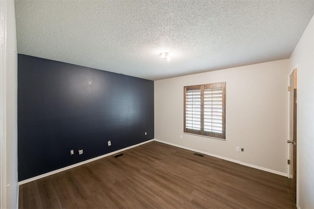 325 S Pine St, Crescent, OK 73028 - spare room with dark wood-type flooring, a textured ceiling, and baseboards