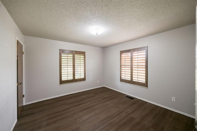 325 S Pine St, Crescent, OK 73028 - empty room featuring dark wood-style flooring, a textured ceiling, and baseboards