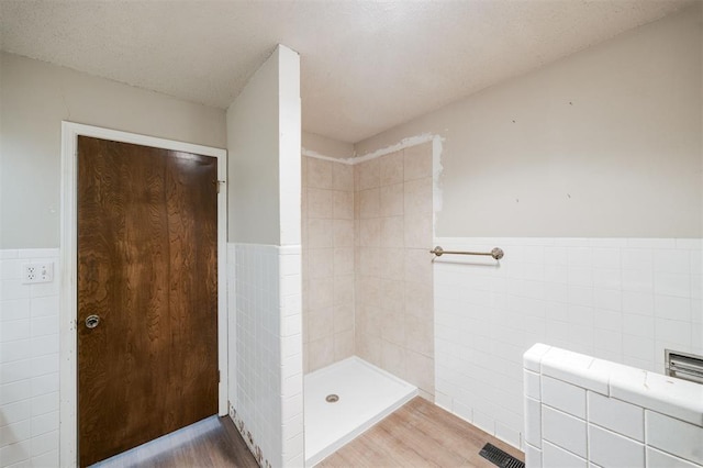 325 S Pine St, Crescent, OK 73028 - full bath with tile walls, a wainscoted wall, a tile shower, and wood finished floors