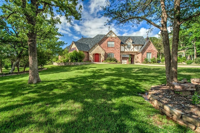 8025 Redbud Canyon Trl, Edmond, OK 73034 - english style home featuring a front lawn, brick siding, and stone siding