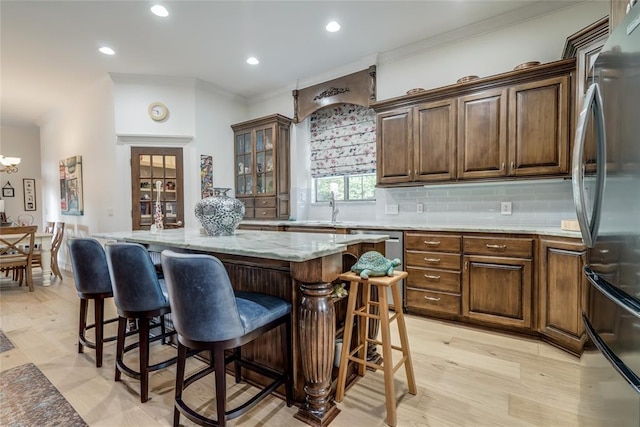 8025 Redbud Canyon Trl, Edmond, OK 73034 - kitchen with freestanding refrigerator, a breakfast bar, ornamental molding, a center island, and decorative backsplash