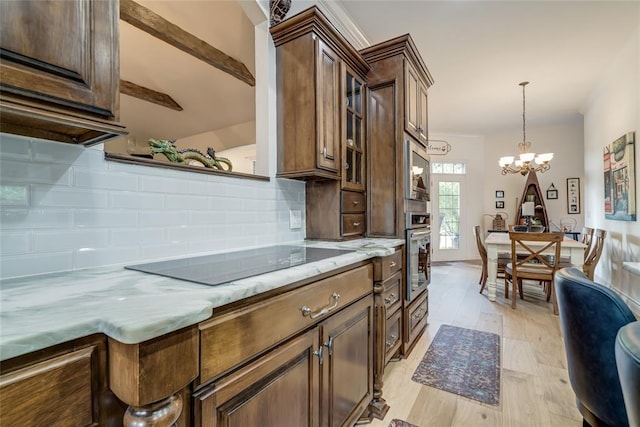 8025 Redbud Canyon Trl, Edmond, OK 73034 - kitchen with appliances with stainless steel finishes, a chandelier, tasteful backsplash, decorative light fixtures, and glass insert cabinets