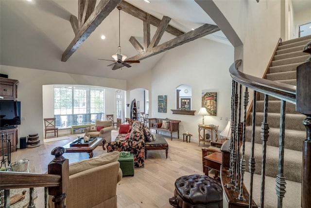8025 Redbud Canyon Trl, Edmond, OK 73034 - living room with arched walkways, beamed ceiling, high vaulted ceiling, stairway, and a ceiling fan