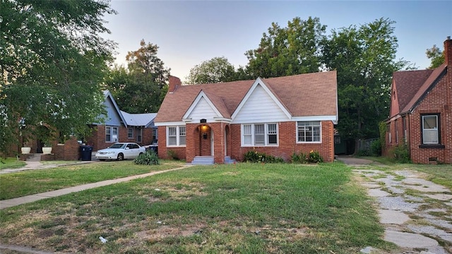 929 NE 17th St, Oklahoma City, OK 73105 - english style home with a front yard, brick siding, and a chimney