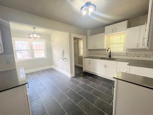 929 NE 17th St, Oklahoma City, OK 73105 - kitchen with a sink, white cabinetry, dark countertops, and baseboards