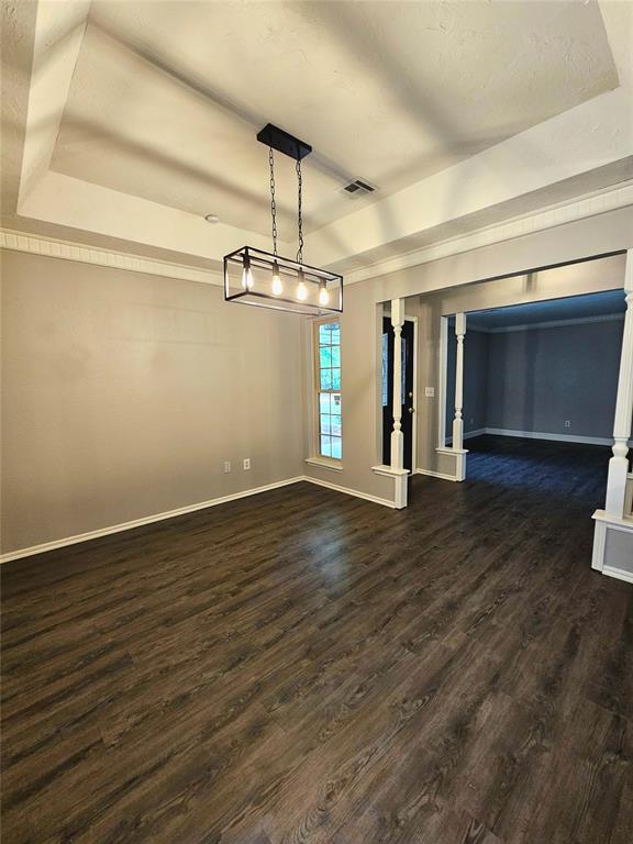 6013 Greenview Dr, Oklahoma City, OK 73135 - unfurnished dining area featuring baseboards, dark wood-style floors, and a raised ceiling