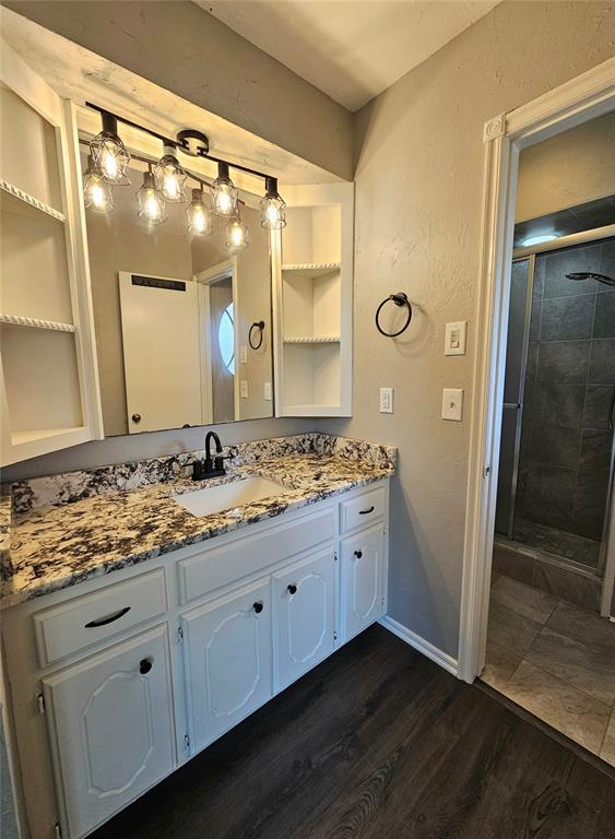 6013 Greenview Dr, Oklahoma City, OK 73135 - full bath featuring vanity, a stall shower, wood finished floors, and baseboards