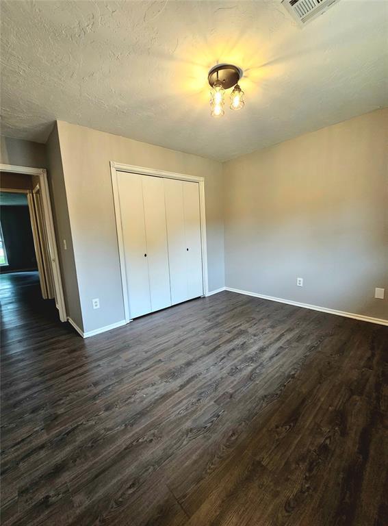 6013 Greenview Dr, Oklahoma City, OK 73135 - unfurnished bedroom with baseboards and dark wood finished floors