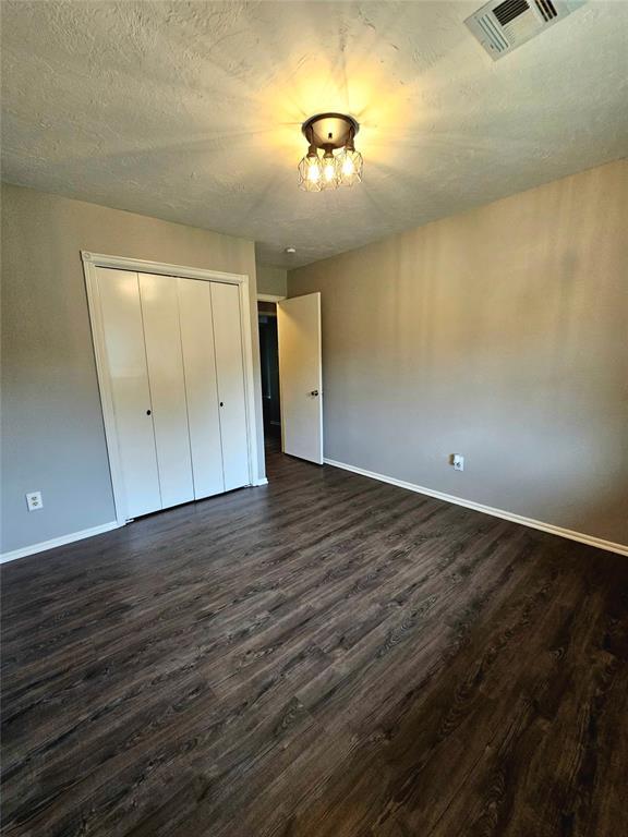 6013 Greenview Dr, Oklahoma City, OK 73135 - unfurnished bedroom with dark wood finished floors, baseboards, and a closet