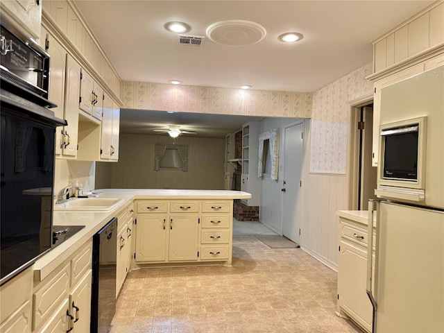 1618 NW 24th St, Lawton, OK 73505 - kitchen with wallpapered walls, a sink, black appliances, a peninsula, and a ceiling fan