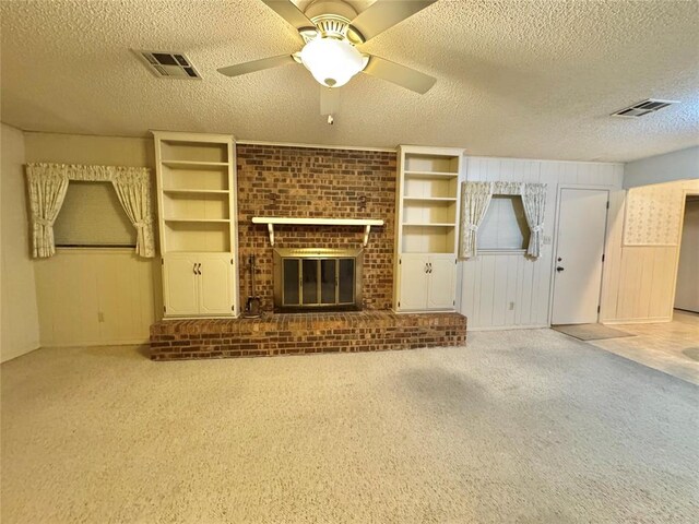 1618 NW 24th St, Lawton, OK 73505 - unfurnished living room featuring a textured ceiling, light carpet, a ceiling fan, and a brick fireplace