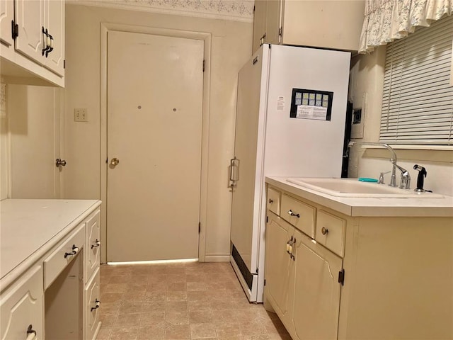1618 NW 24th St, Lawton, OK 73505 - kitchen featuring a sink, light countertops, freestanding refrigerator, and baseboards