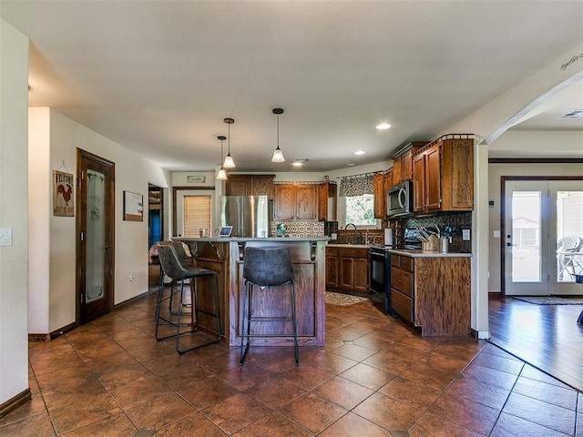 5509 Old Town St, Newalla, OK 74857 - kitchen featuring appliances with stainless steel finishes, a kitchen breakfast bar, baseboards, decorative backsplash, and recessed lighting