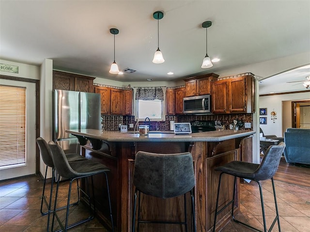 5509 Old Town St, Newalla, OK 74857 - kitchen featuring appliances with stainless steel finishes, tasteful backsplash, decorative light fixtures, a kitchen bar, and recessed lighting