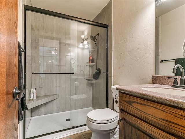 5509 Old Town St, Newalla, OK 74857 - bathroom with a textured wall, vanity, toilet, a shower stall, and tile patterned flooring