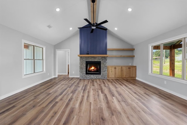 3155 E Fair St, Idabel, OK 74745 - unfurnished living room with a ceiling fan, a stone fireplace, wood finished floors, baseboards, and beam ceiling