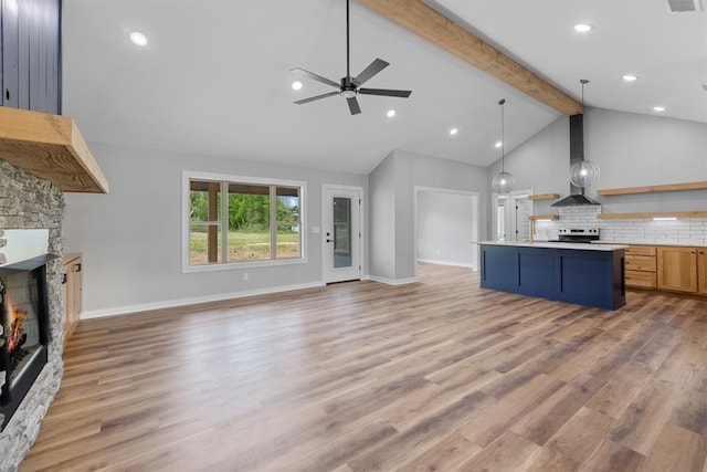 3155 E Fair St, Idabel, OK 74745 - kitchen featuring wall chimney range hood, open floor plan, a fireplace, open shelves, and beamed ceiling