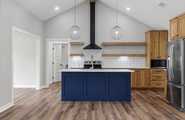 3155 E Fair St, Idabel, OK 74745 - kitchen featuring open shelves, appliances with stainless steel finishes, wall chimney exhaust hood, light countertops, and an island with sink