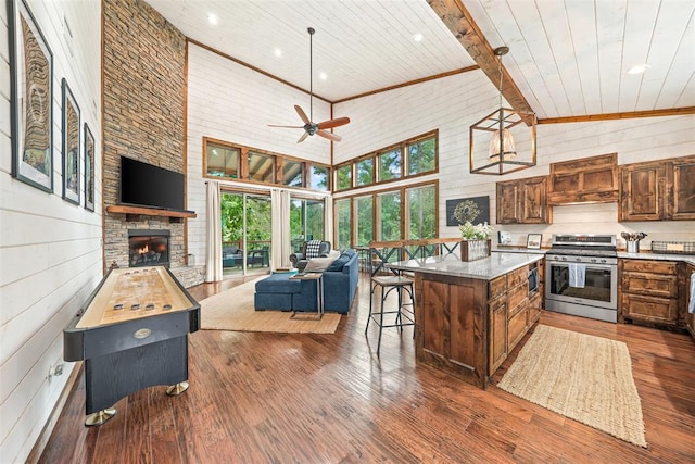 168 Eagle Mountain Trl, Broken Bow, OK 74728 - kitchen with stainless steel range with gas stovetop, open floor plan, wooden ceiling with exposed beams, ceiling fan, and a center island