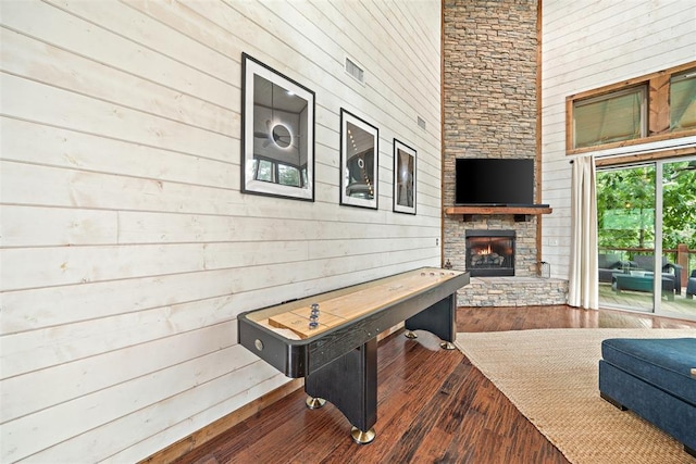 168 Eagle Mountain Trl, Broken Bow, OK 74728 - living room featuring wood walls, a fireplace, wood-type flooring, and a high ceiling