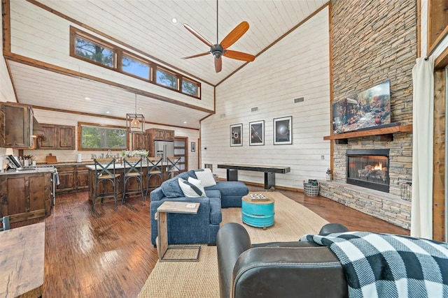 168 Eagle Mountain Trl, Broken Bow, OK 74728 - living area featuring dark wood-style flooring, high vaulted ceiling, a ceiling fan, a fireplace, and wooden walls